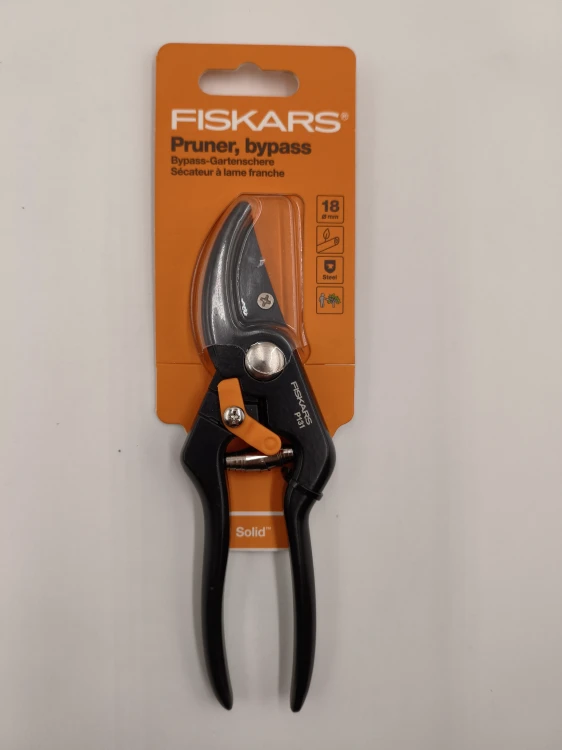 Sekator nożycowy Fiskars Solid P131 w pomarańczowym opakowaniu tnie świeże gałęzie do 18 mm.