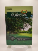 Pudełko trawy Parkowej Granum z drzewami w tle sugeruje zastosowanie w cieniu.
