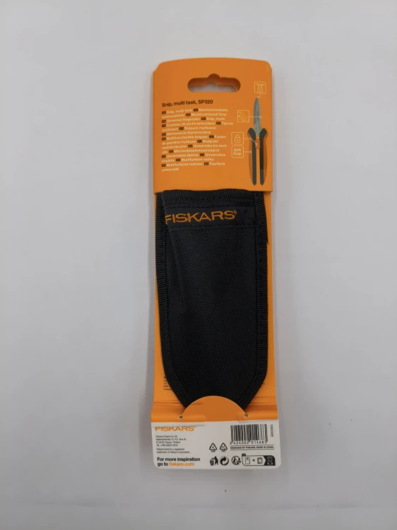 Tył opakowania nożyczek Fiskars SP320 prezentuje czarne materiałowe etui dołączone do zestawu narzędzi.