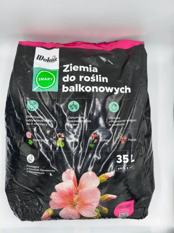 Front czarnego worka 35L z ziemią WOKAS SMART do roślin balkonowych prezentujący różowe pelargonie.