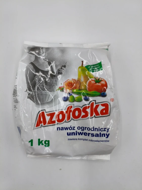 Przód opakowania 1 kg uniwersalnego nawozu ogrodniczego AZOFOSKA z uśmiechniętą ogrodniczką i zebranymi plonami.